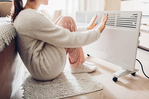Cold woman by radiator