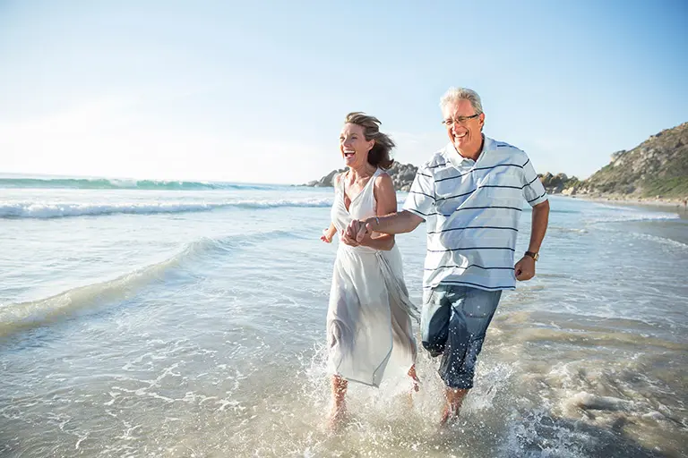 Older couple running on beach